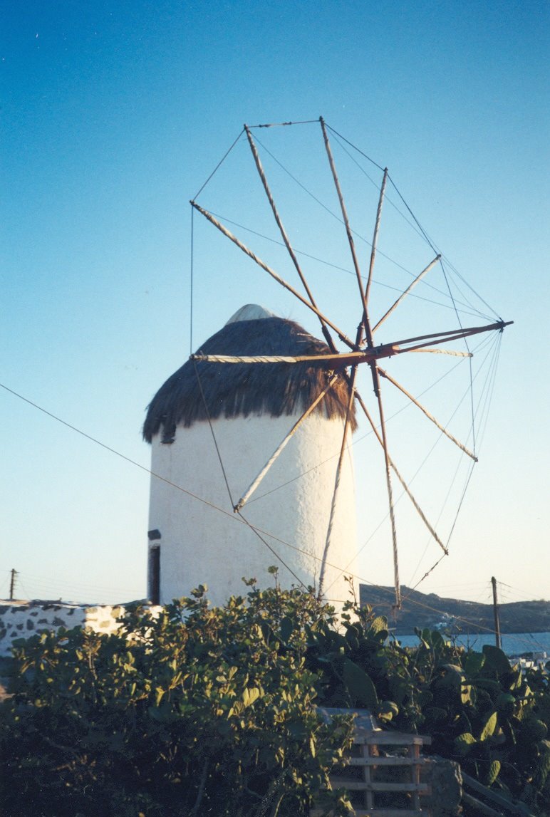 Mulino a vento bianco con tetto di paglia e pale lignee a Mykonos
