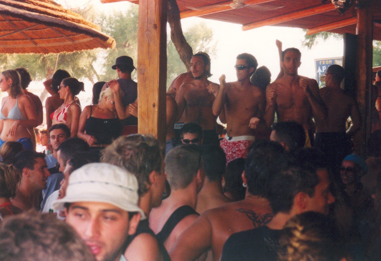 Festa al chiosco di spiaggia, ragazzi in costume ballano sotto il legno