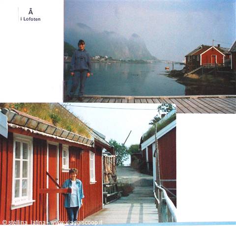 Child on wooden pier and red timber houses in Å, Lofoten, misty mountains behind