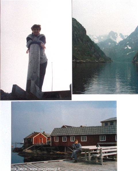 Boy on wooden pier, snowy mountains over fjord, red cabins on stilts