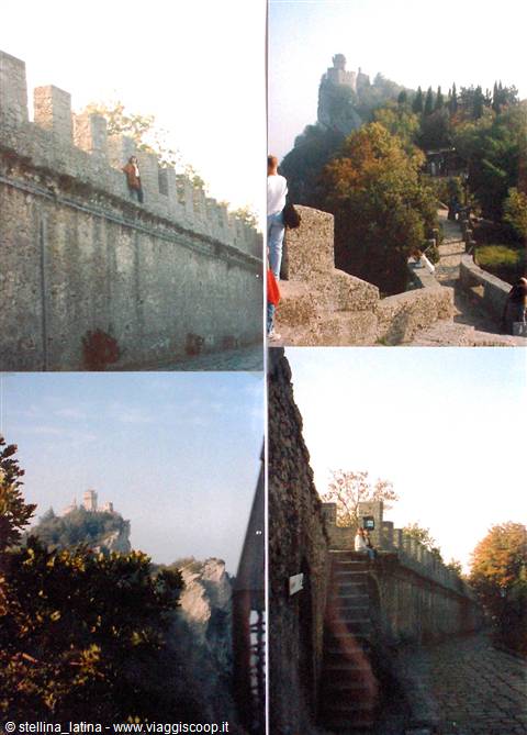 Tourists on crenellated fortress walls of San Marino among autumn trees