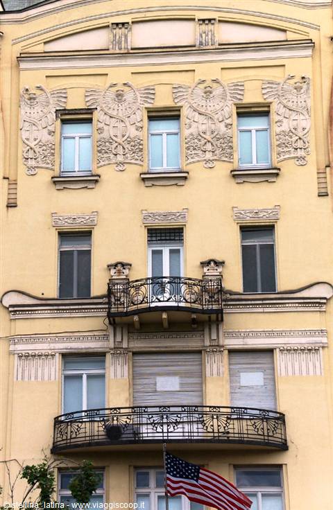 Art Nouveau yellow facade with carved owl reliefs and wrought-iron balconies