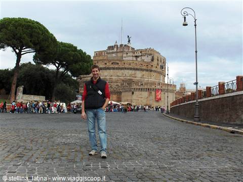 Smiling tourist on cobblestone avenue in front of Castel Sant'Angelo, Rome