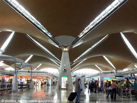 Kuala Lumpur airport hall, curved wooden roof, skylight glare, travelers with luggage