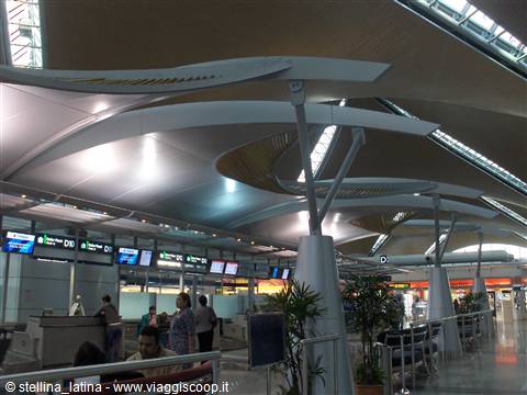 Check-in counters beneath the curved white structures of Kuala Lumpur airport