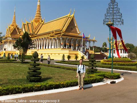 Tourist in front of the Royal Throne Hall, golden roof and manicured gardens