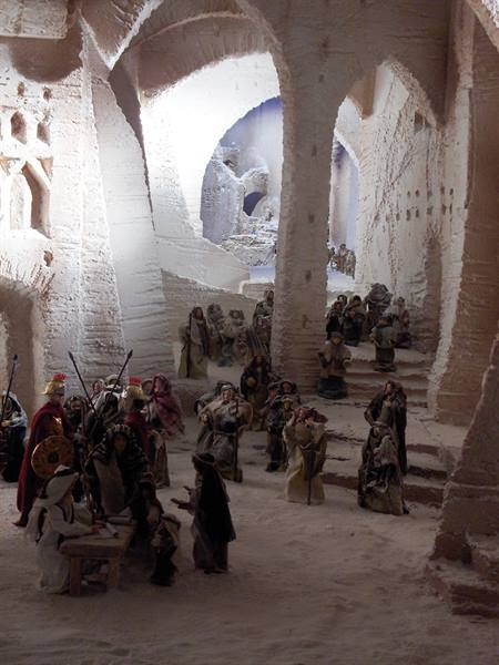 Nativity scene with figurines among white stone arches and stairways