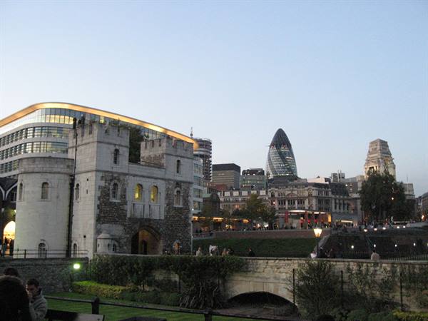 Stone Tower of London at dusk, Gherkin skyscraper glowing behind