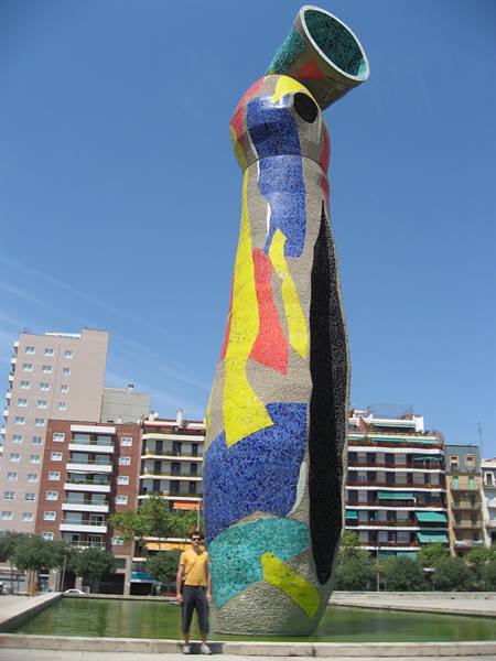 Miró's Dona i Ocell mosaic sculpture in Barcelona, man standing beside it