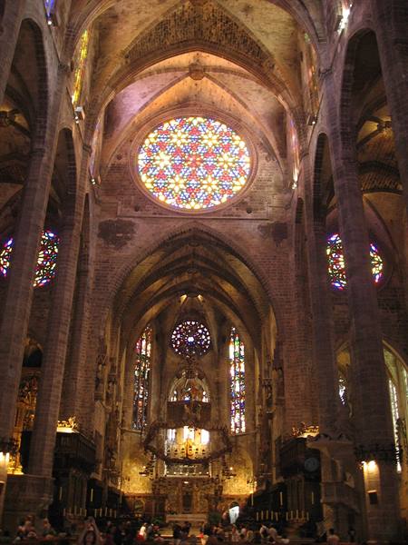 Stained-glass rose window over the nave of Palma de Mallorca cathedral, colored light on stone vaults