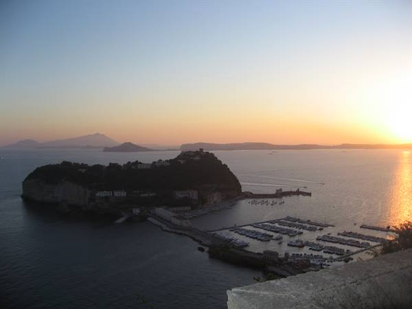 Nisida at sunrise, the sea reflects golden light near Naples