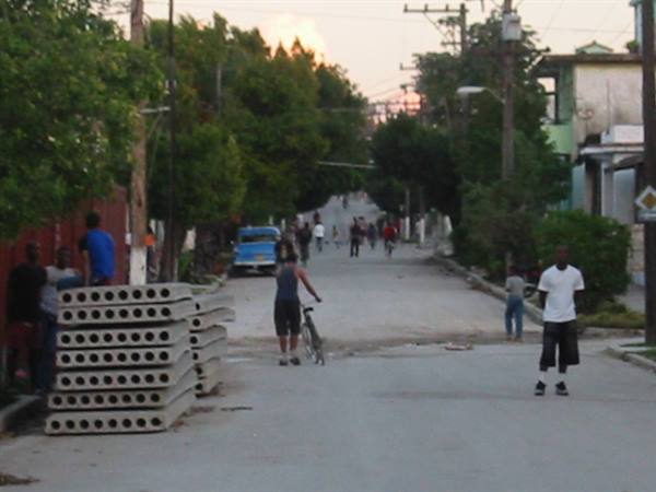 Man with bicycle and concrete pillars on a street at dusk