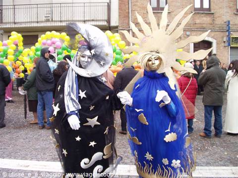 Carnival: two performers in moon and sun costumes in a crowded square
