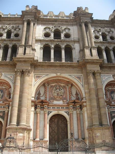 Baroque facade of Málaga Cathedral, stone portal in sunlight