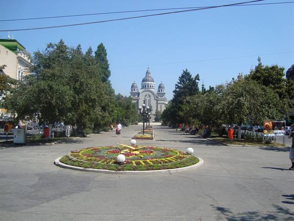 Floral clock on a tree-lined square, Cluj-Napoca Cathedral in the background