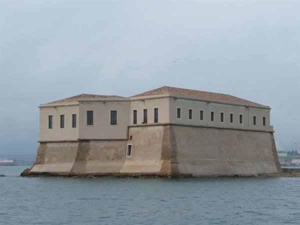 Lazaretto of Trieste: eighteenth-century stone building on the water, grey sky