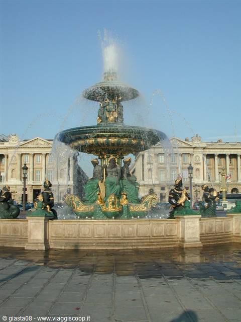 Green and gilded fountain spraying water at Place de la Concorde, Paris