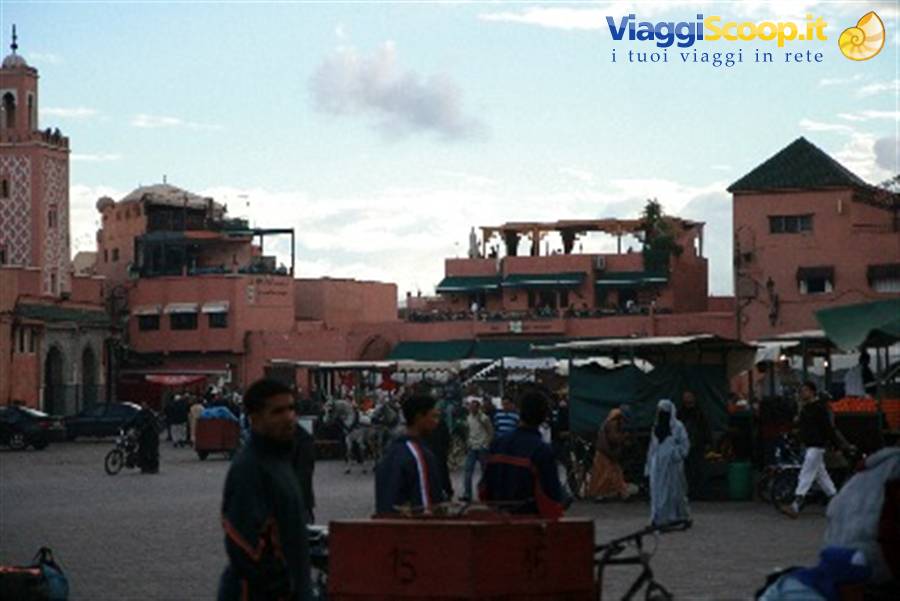 Jemaa el-Fna square in Marrakech, red buildings, minaret and food stall