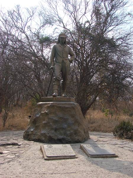 Bronze statue of David Livingstone on rock base, commemorative plaques, bare trees behind
