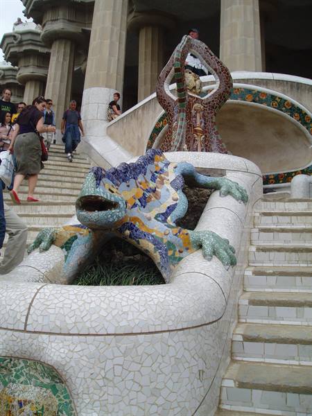 Gaudí's mosaic salamander at Park Güell, with tourists on the steps