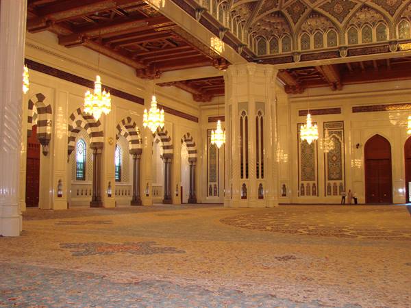 Prayer hall of the Grand Mosque of Muscat, lit chandeliers and mosaics