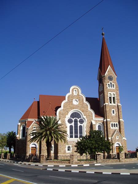 Christuskirche in Windhoek, sandstone church with red spire under blue sky