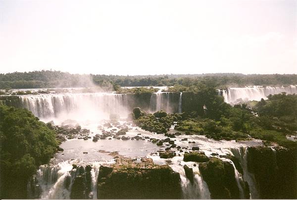 Iguazú Falls, cascading water and mist among rocks and green forest