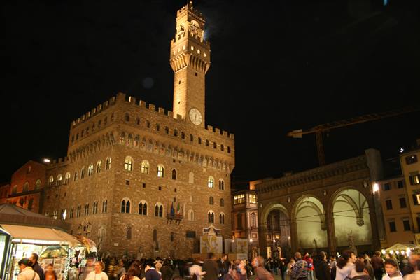 Palazzo Vecchio lit at night, crowd in Piazza della Signoria, Florence