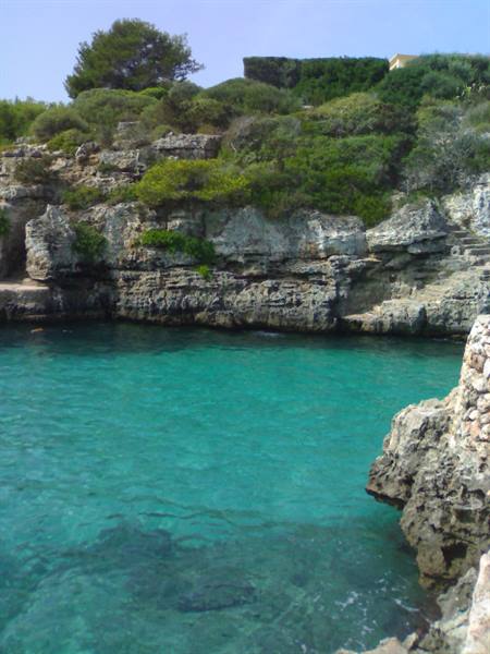 Turquoise water between limestone cliffs and Mediterranean shrubs, Mallorca