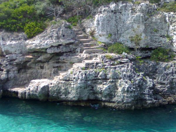 Stone steps carved into limestone cliff above turquoise water