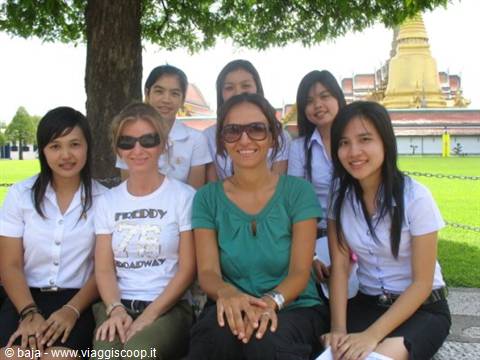 Group of girls in white shirts in front of Wat Phra Kaew golden stupa, Bangkok