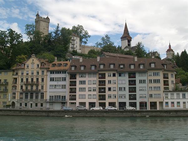 Riverside houses with a tower and spires in Lucerne