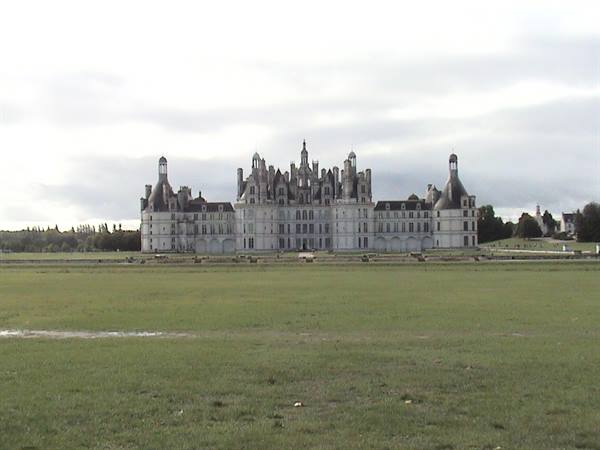 The Château de Chambord with its spires, behind a wide green lawn