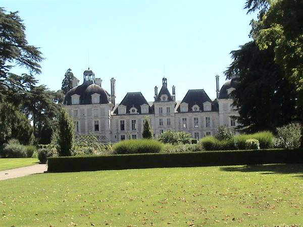 The stone Château de Cheverny behind green lawns and hedges