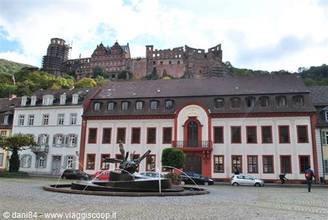 Heidelberg Castle overlooks the square with fountain and historic buildings