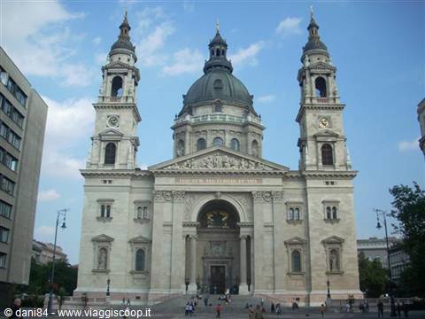 Stone facade with twin bell towers and green dome of St Stephen's Basilica