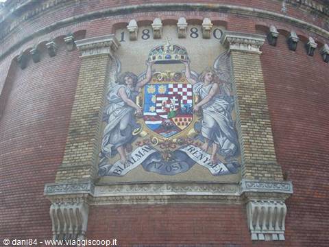 Coat of arms mosaic with angels dated 1880 on red bricks
