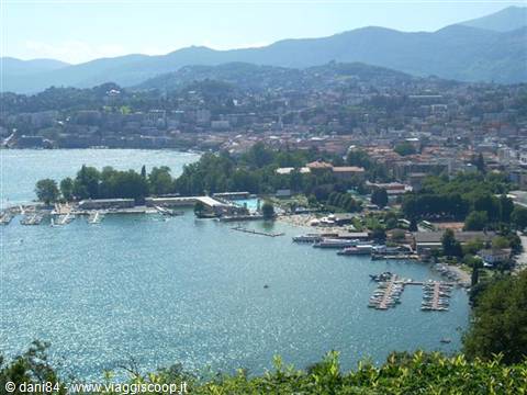 Marinas and beaches along Stresa lakefront, blue water and mountains behind