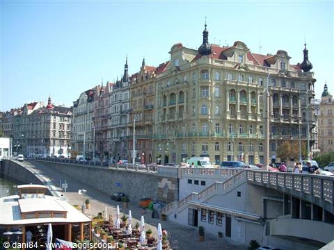 Art Nouveau buildings along the Vltava in Prague, boats and pedestrians below