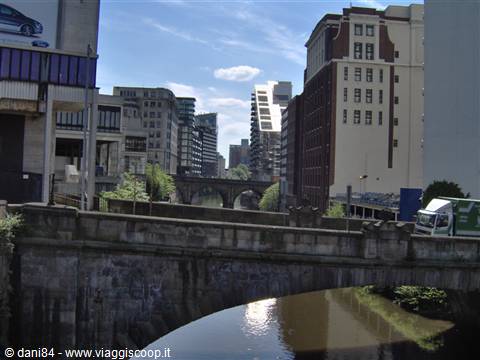 Stone bridge over the River Irwell among Manchester buildings