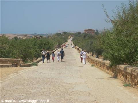 Tourists walk the Via Sacra at the Valley of the Temples toward Concordia temple