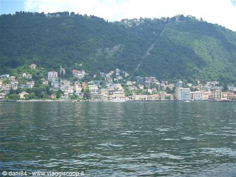 Colorful houses on Lake Como shore, surrounded by green mountains