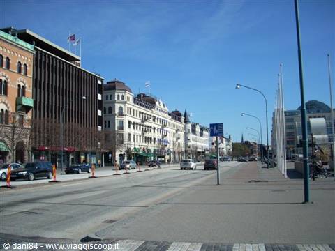 Wide street with historic buildings and cars under blue sky in Gothenburg
