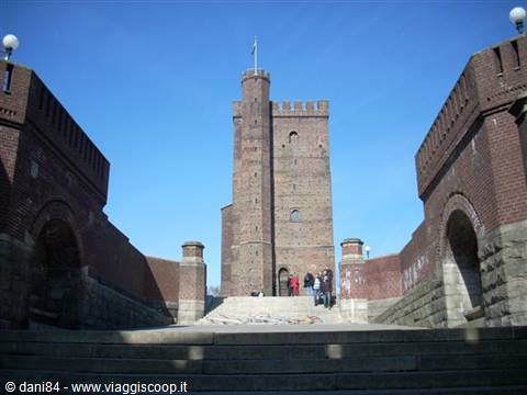 Tourists on stone steps toward Helsingborg's medieval Kärnan tower, red brick, blue sky