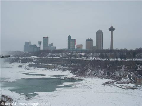 Skyscrapers and Skylon Tower above frozen Niagara Falls, grey sky