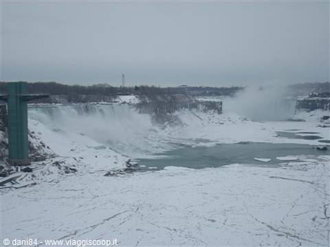 Frozen Niagara Falls, mist rising over icy river and snow