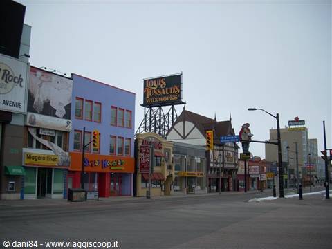 Empty street with Louis Tussauds Waxworks sign and colorful shops on Clifton Hill, Niagara Falls