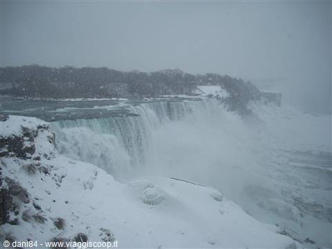 Snow-covered Niagara Falls, water plunging into wintry mist