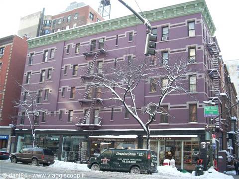 Purple building with fire escapes on a snowy street in Greenwich Village