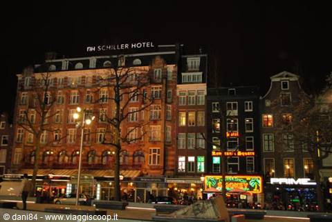 Illuminated buildings at night on Rembrandtplein in Amsterdam, neon signs